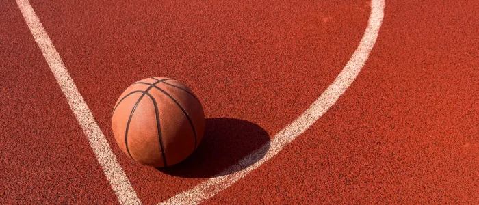 Top view orange ball for basketball lying on the rubber sport court. Sport red ground outdoor in the yard. High quality photo